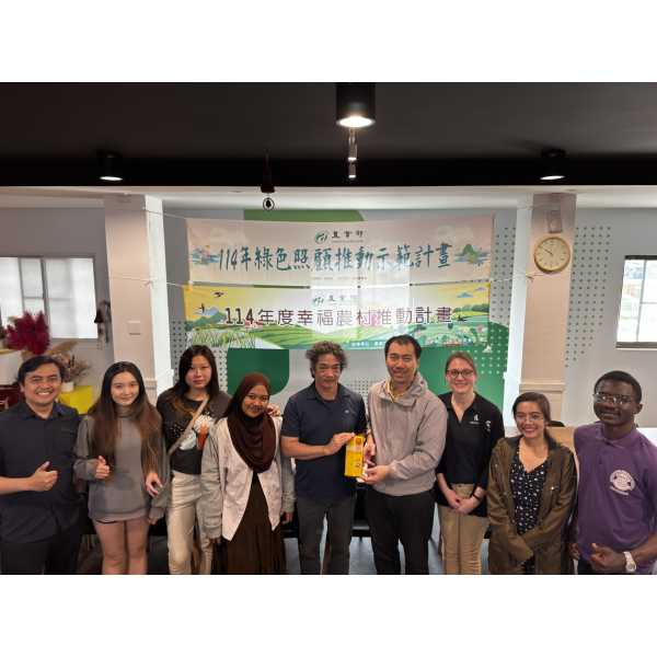MSU Extension AgriAbility Sam Wolfe with a group of Taiwanese students standing in front of a sign in Chinese.