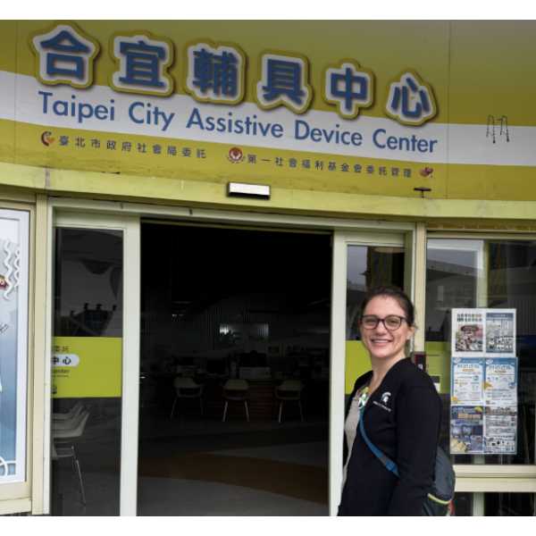 MSU Extension Educator in Taiwan standing in front of the entrance to the Taipai City Assitive Device Center