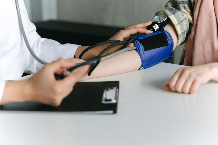 A photo of a doctor taking a patients blood pressure.