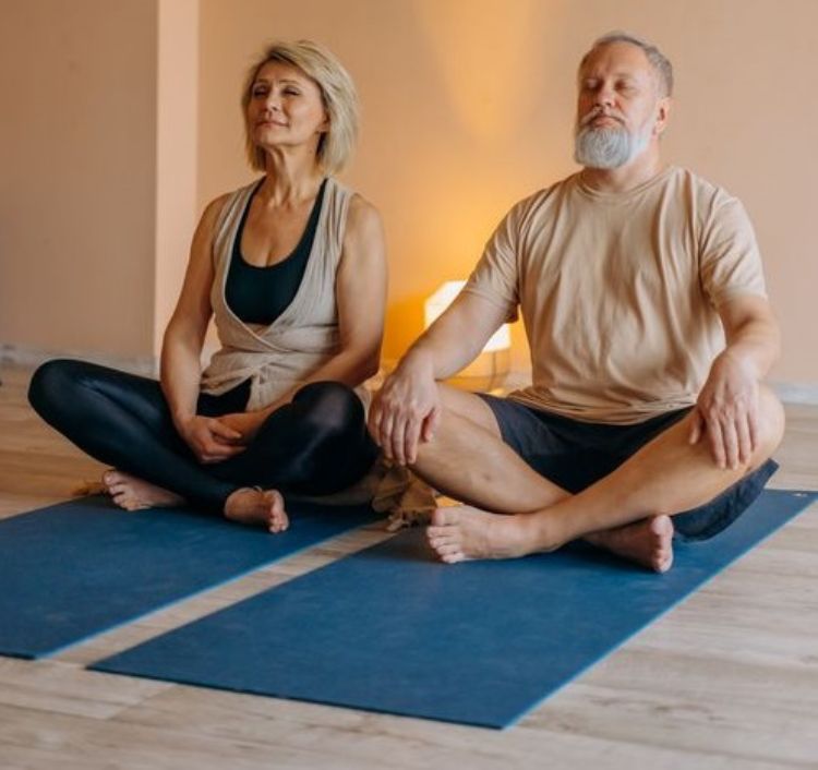 An elderly couple meditating.