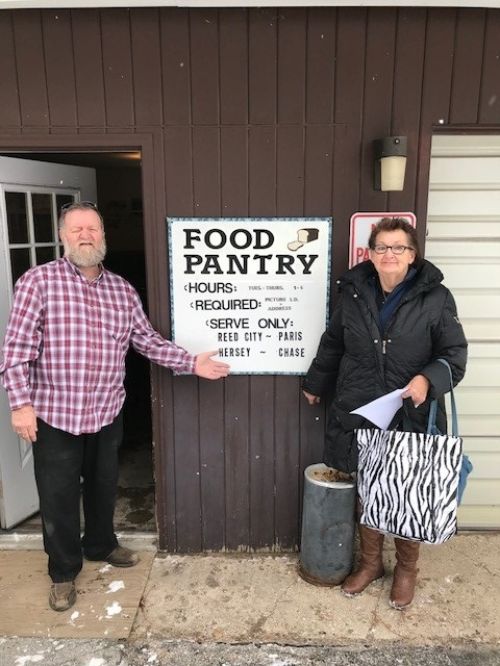 Burley Russell, director of the Reed City Food Pantry in Osceola County, poses with pantry client Sharon Lee-O'Brien.