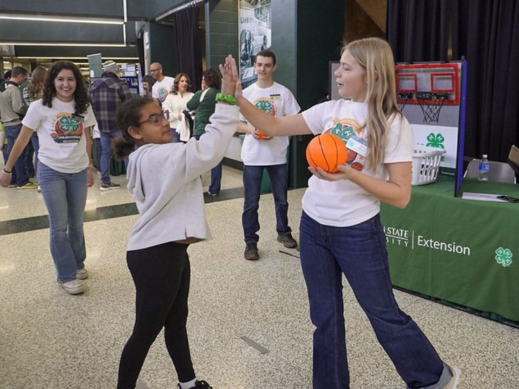 Two girls giving each other a high five.