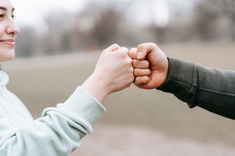 A photo of two people giving each other a fist bump.