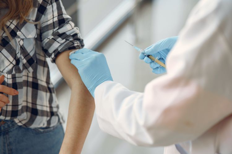 A medical professional administering a vaccine to someone.