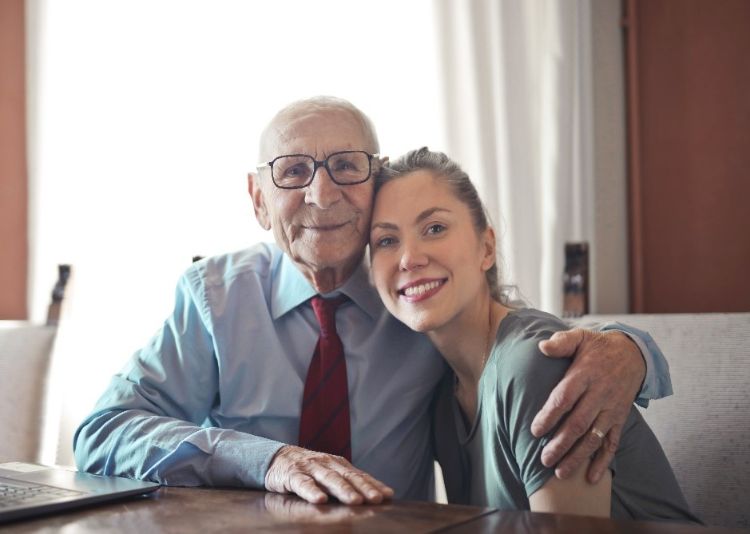 An elderly man hugging a young woman.