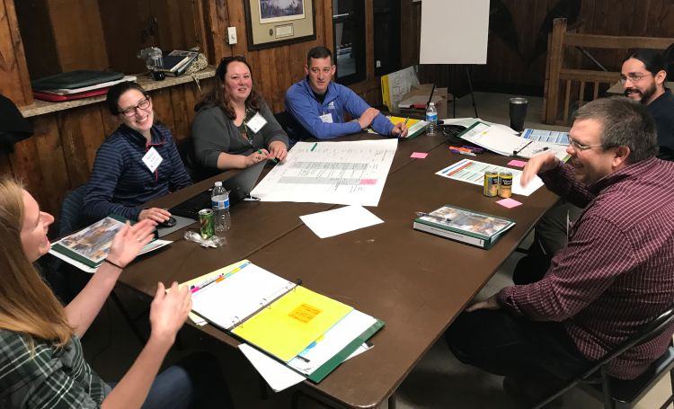 People sitting around table at a meeting having a discussion.