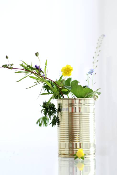Image displays a tin can with flowers and leaves.