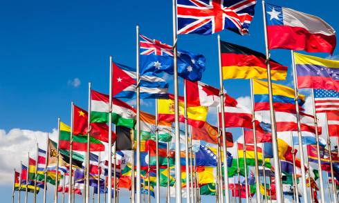 International flags blowing against a blue sky.