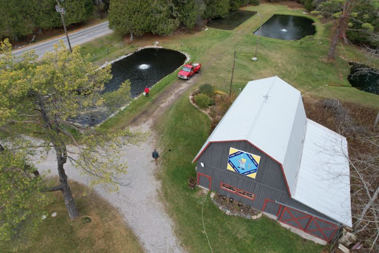 An overhead view shows Cedarbrook Trout Farms and aquaculture farmers can be seen standing near a pond next to a barn.