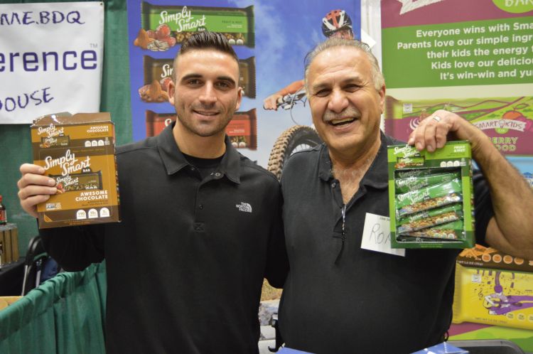 Two men holding up granola bars