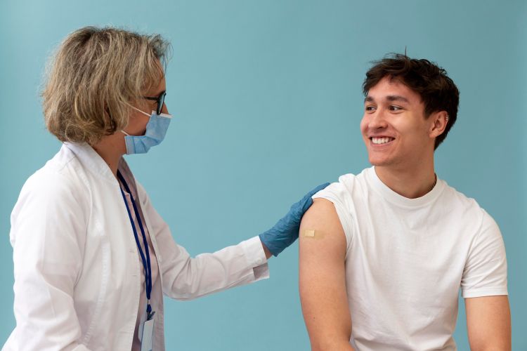 Photo of a doctor talking to a patient after administering a vaccine.