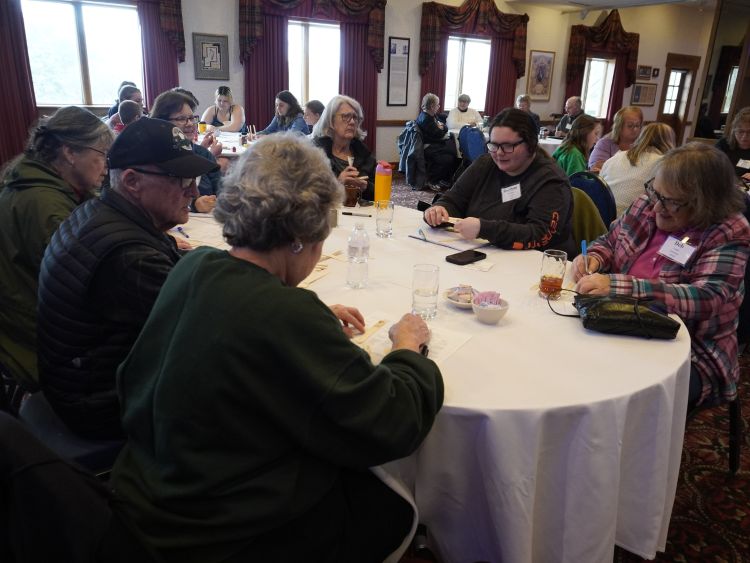 A group of volunteers sitting around a table at a conference.