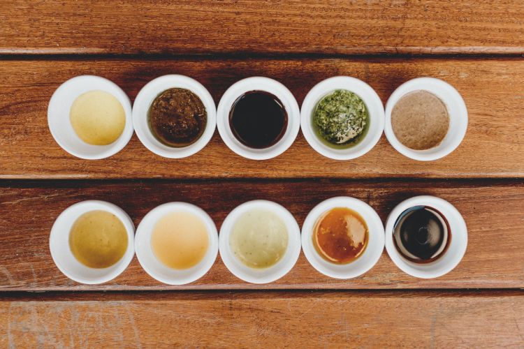 Overhead view of many sauces and spices in containers.