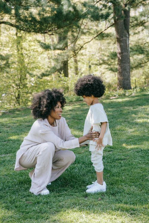 A mother crouches down to talk to her child.