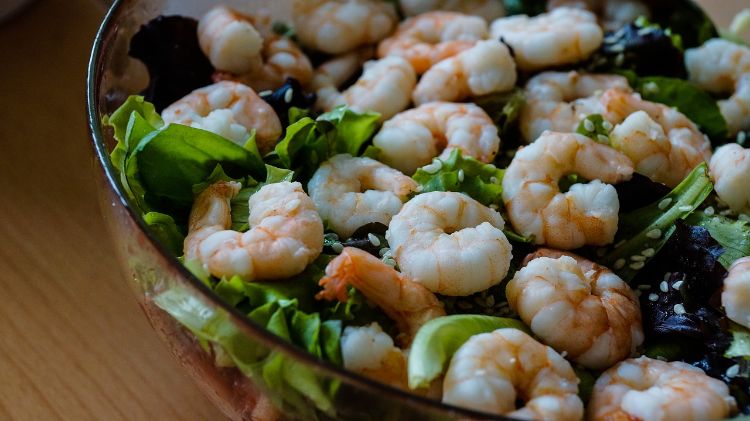 A salad with dark leafy greens and shrimp is an example of pairing iron and vitamin C in a meal.