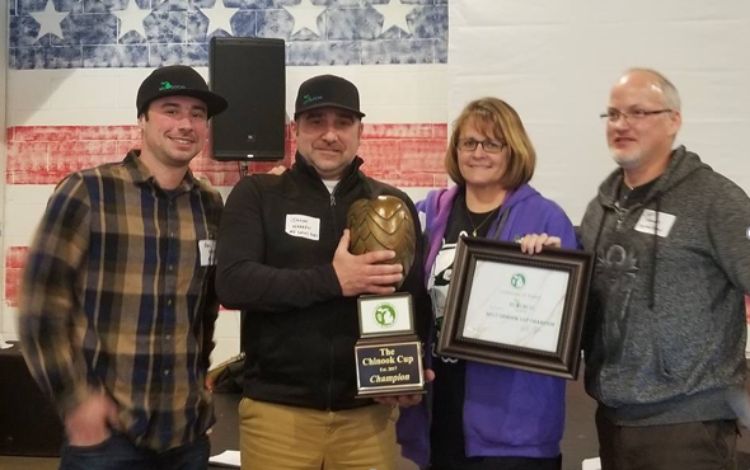 MI Local’s Alex Wiesen (left) and Jason Warren (tightly gripping trophy) receive the 2017 Chinook Cup from the Hop Growers of Michigan.