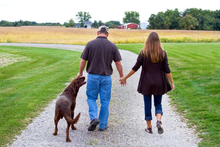 A farming family walks along a pathway on their property.