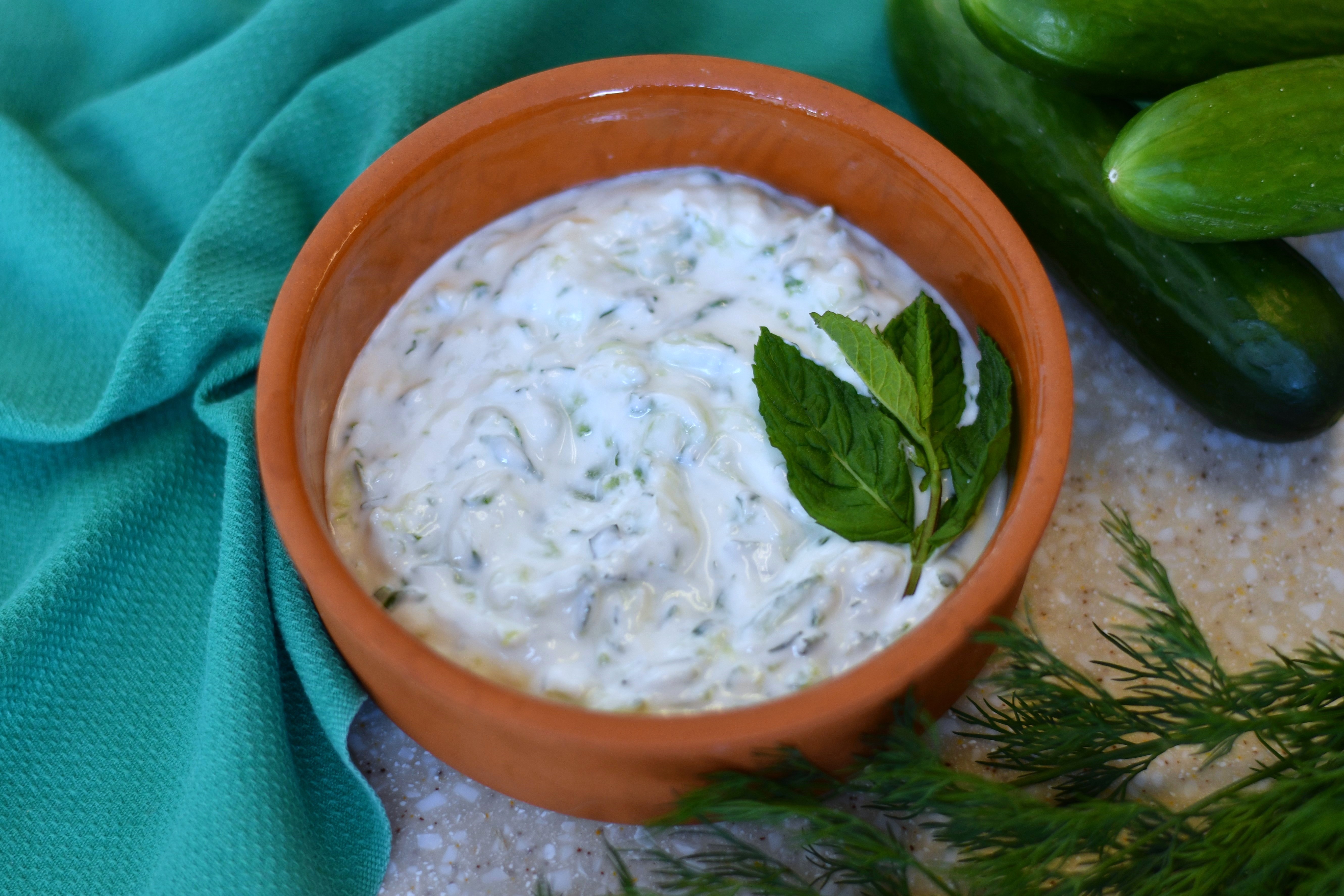 A photo of a bowl with a white dip topped with mint leaves