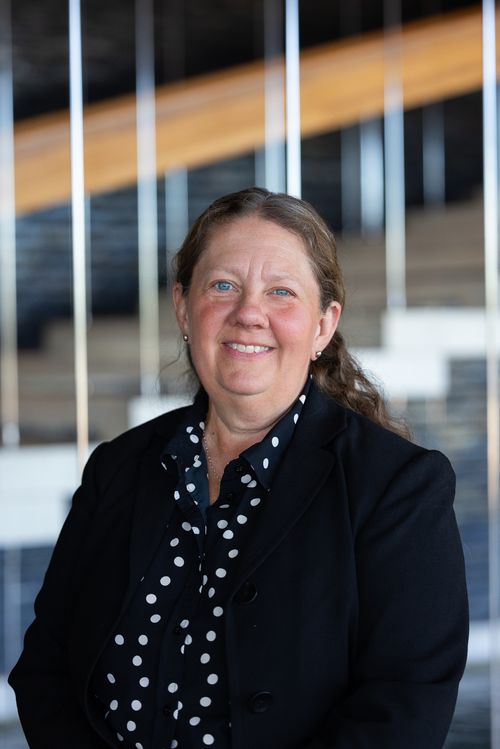 A woman in a black blazer.
