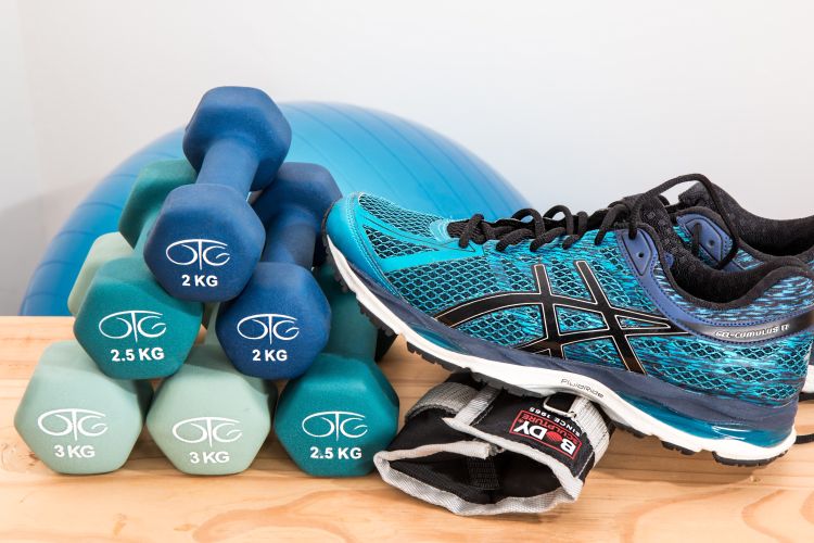 A photo of free weights and a running shoe sitting on a table.