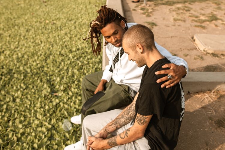 Two young people talking and comforting each other.