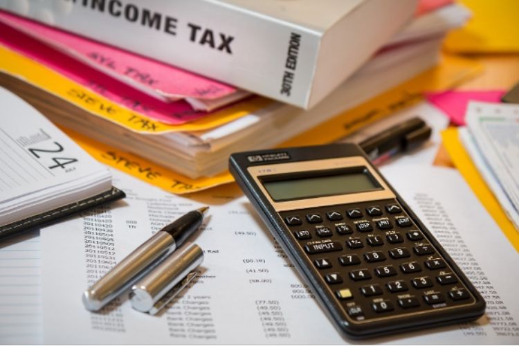 Calculator, pen, income tax book and papers