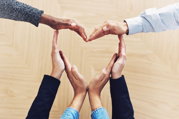 A heart shaped made by people's hands.