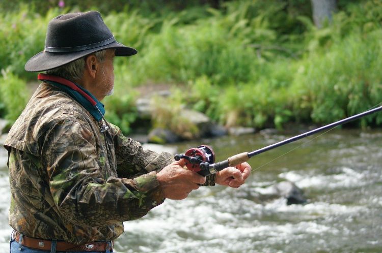 Man seen from waist up fishing in river. Photo: Barbara Jackson/Pixabay