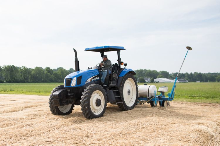 Farmworker drives a tractor on a field