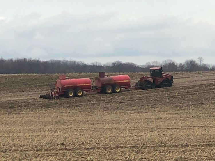 Farm machinery shown in a field spreading manure. Utilizing manure as a fertilizer source can be a cost-effective way for farmers to meet crop nutrient needs, and with effective application, be environmentally sustainable. Photo: Beth Ferry, MSU Extension