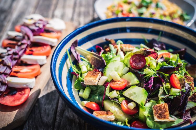 Bowl of salad on a wooden table.