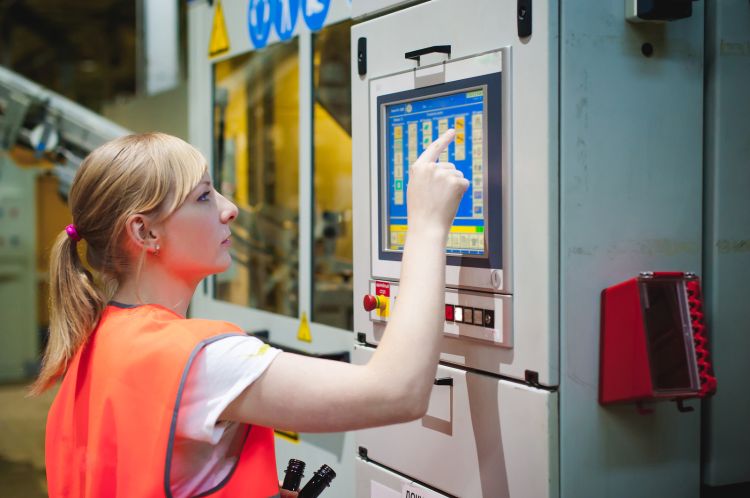 Factory quality control worker using a touch screen.