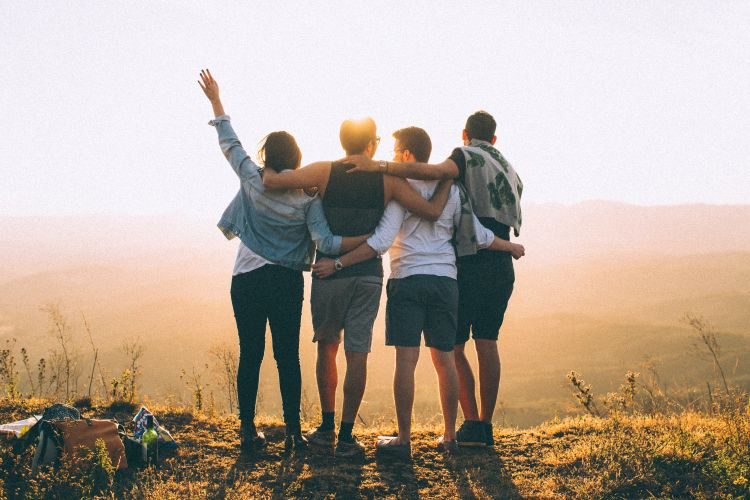 People celebrating outdoors and embracing.