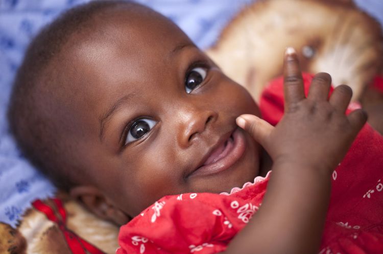 A smiling baby in a red outfit.