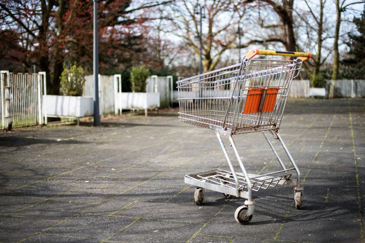 An empty shopping cart in an empty parking lot.