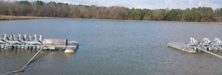 An aquaculture pond is shown with paddlewheel aerators.