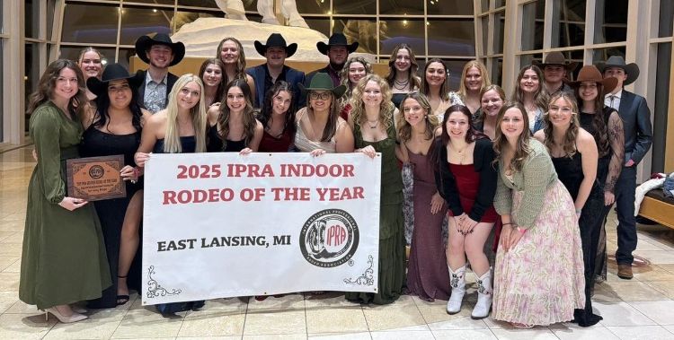 Members of the MSU Rodeo Club gather around a banner that says 