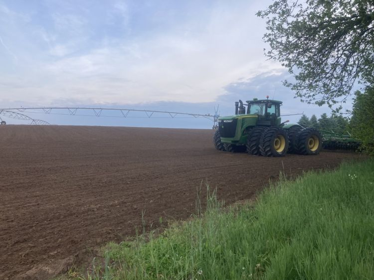 A John Deere tractor in an empty field.