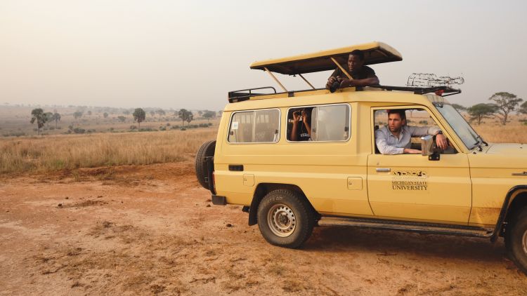 MSU grad student, Tutillo Mudumba (top), Assistant Professor, Robert Montgomery, and Research Assistant Sophia Jingo, look for wildlife in Murchison Falls.