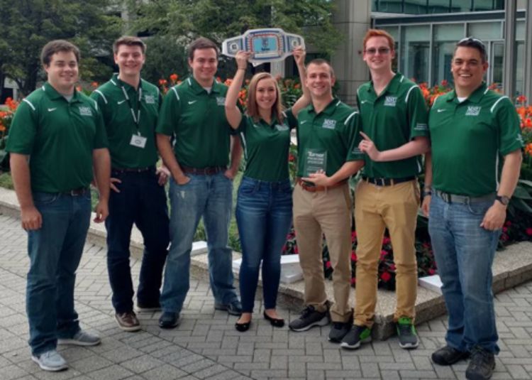 The six members of the Construction Management Commercial Competition team and their coach pose together with their award.