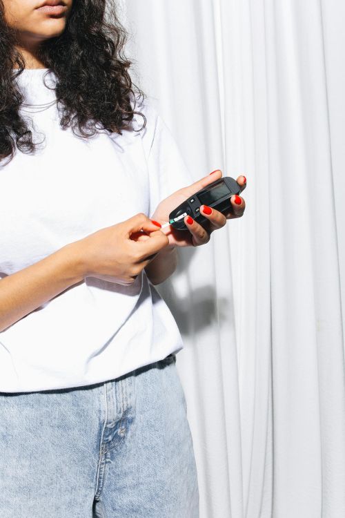 A young woman checking her blood sugar.