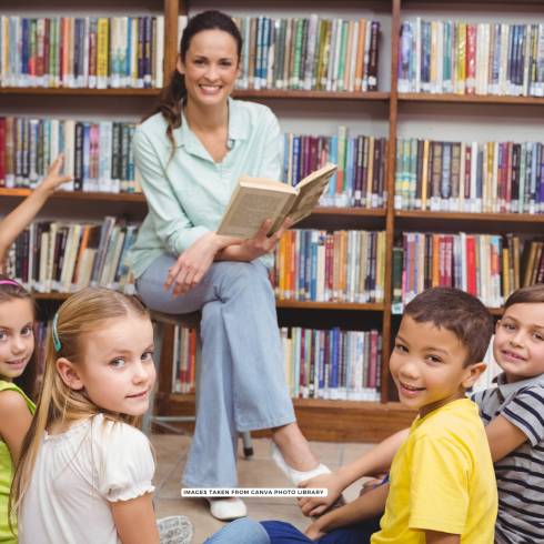 Women reading a story to a group of kids