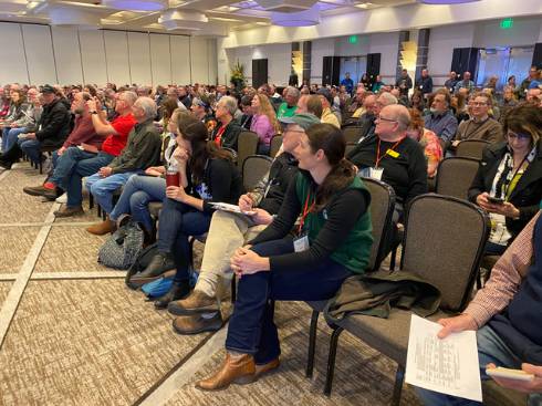 Photo of a seated audience at a beekeeping conference.