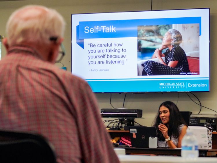 Elderly man sits in a class hosted by Dr. Miloni Rathod on self-talk