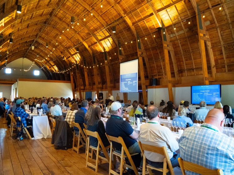 Attendees of the Dirt to Glass Conference sitting at tables watching a presentation.