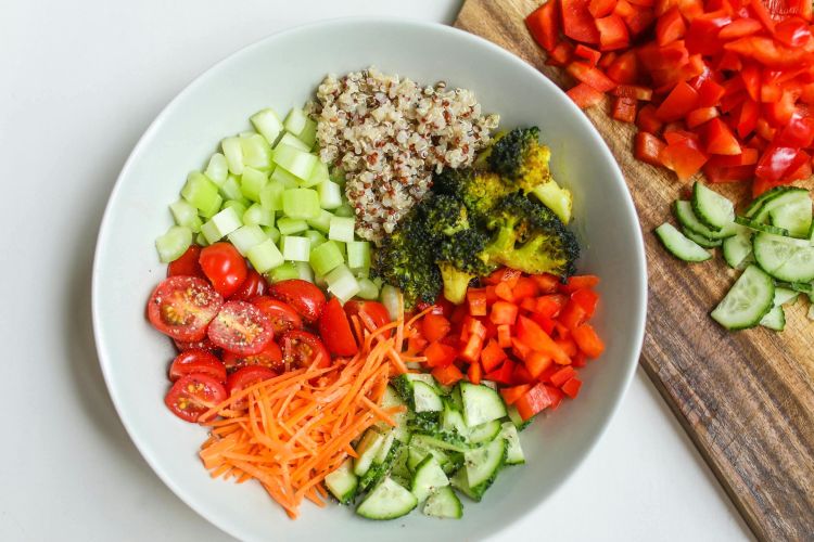 A photo of a bowl full of quinoa and an assortment of colorful vegetables.
