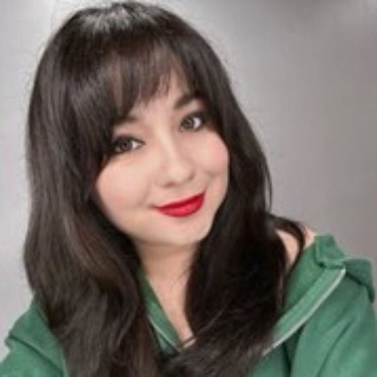 A dark haired woman with bright red lipstick and a green shirt.