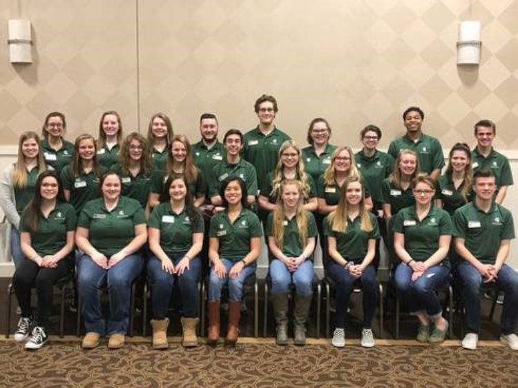 Over 20 youth sitting with green 4-H shirts.