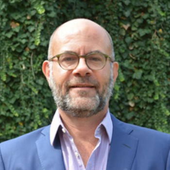 Dr. Robert Richardson in front of a garden wall.