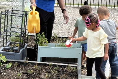 Young children learn to care for the edible plants grown at their child care program